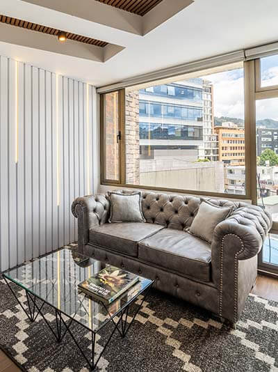 Living area and open sliding door with view into bedroom